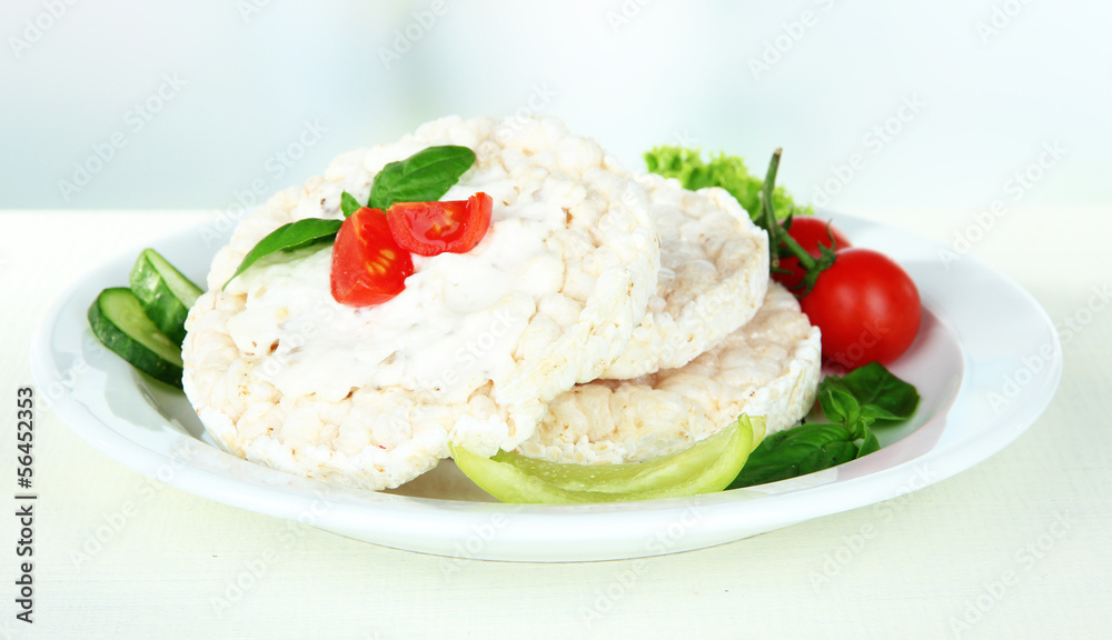 Tasty crispbreads with vegetables on white table Tasty crispbreads with vegetables on white table
