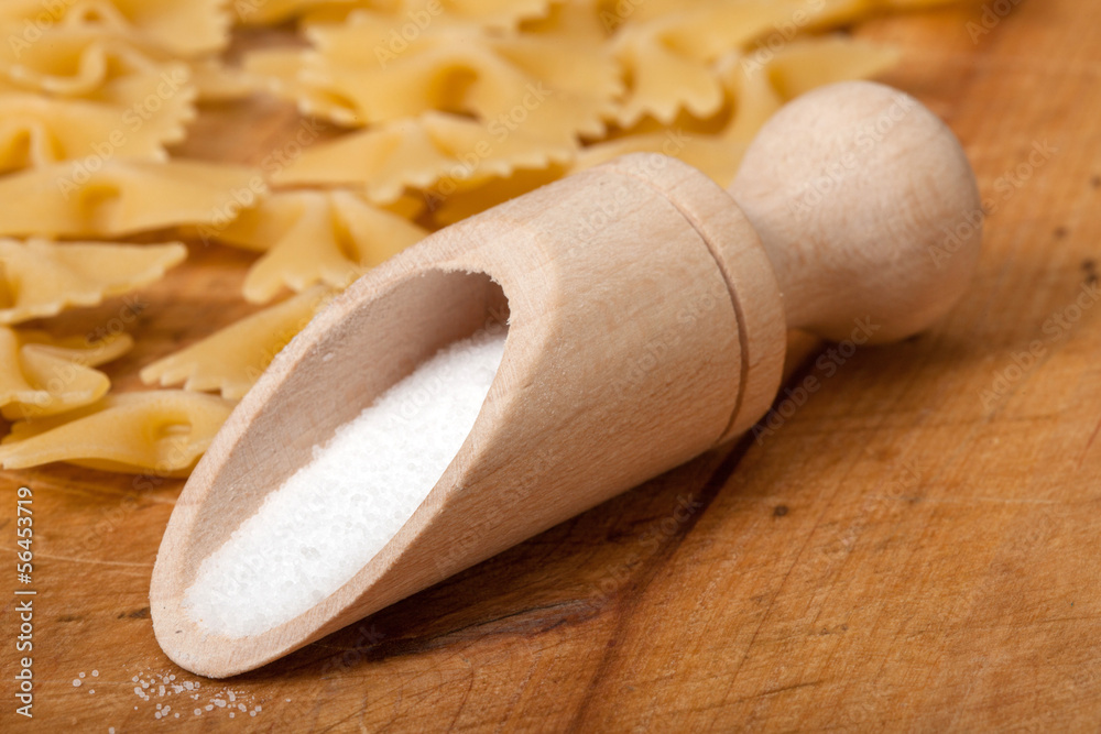 Salt and dry pasta on a wooden board