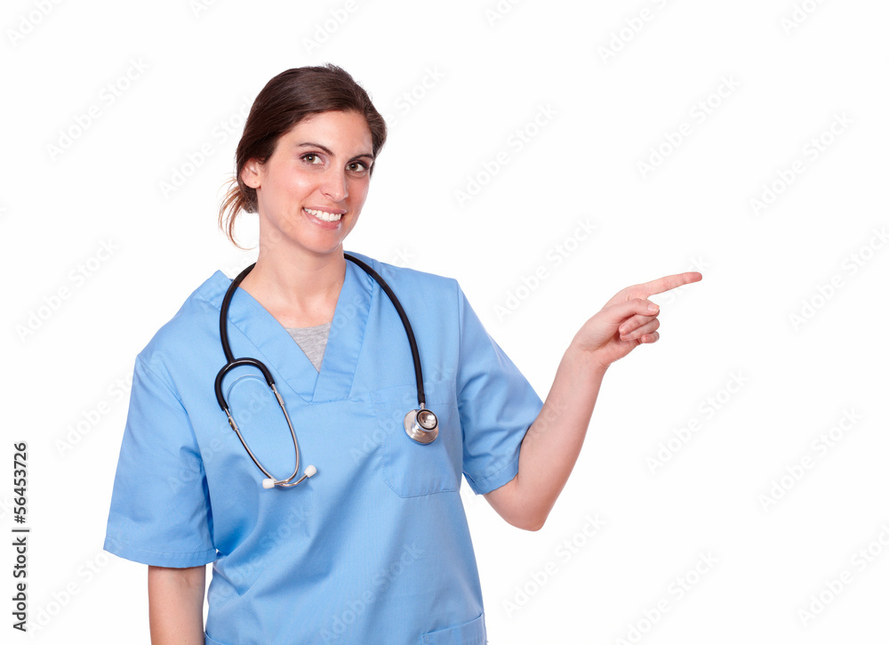 Attractive smiling nurse pointing at her left Attractive smiling nurse pointing at her left