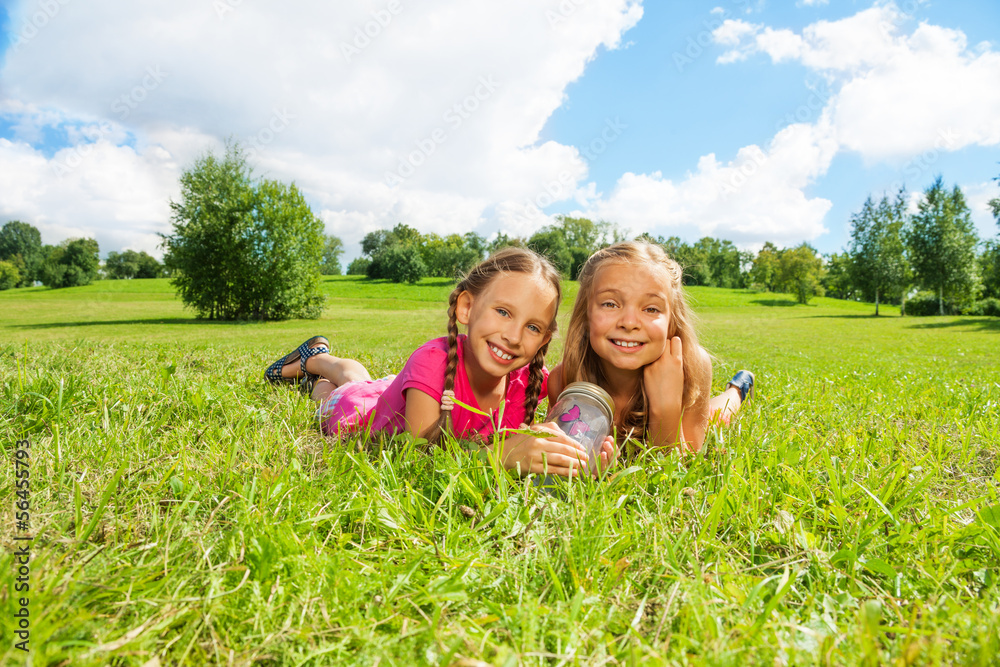 Fototapeta premium Two girls in the grass with butterfly