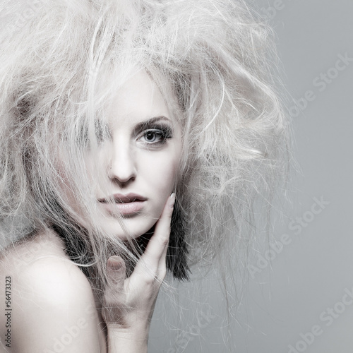 portrait of sexy whiteheaded young woman with blue eyes on grey 