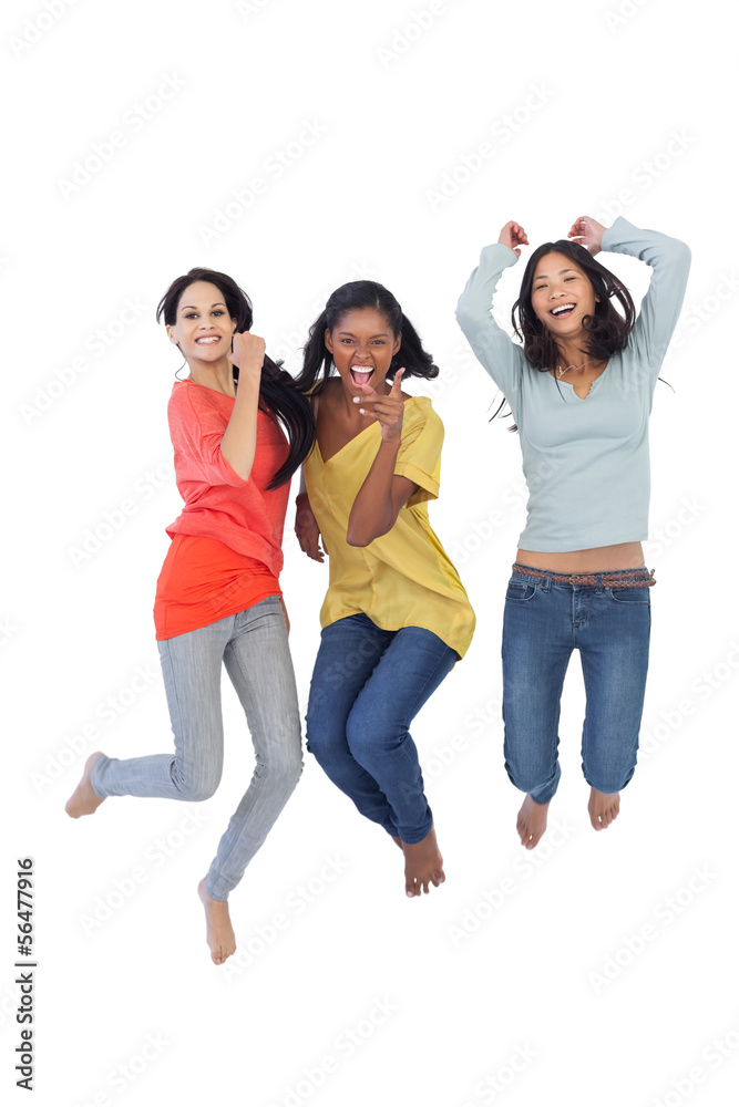 Diverse young women jumping and looking at camera Diverse young women jumping and looking at camera