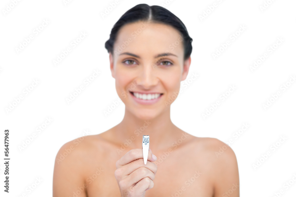 Smiling young brunette holding nail clippers Smiling young brunette holding nail clippers
