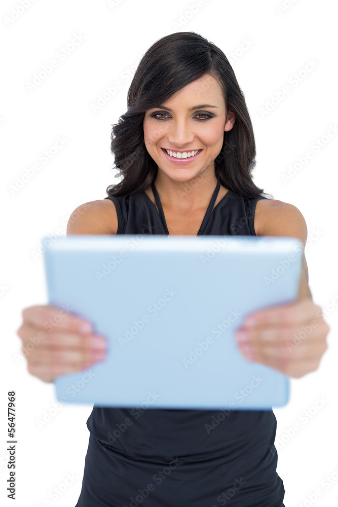 Happy elegant brown haired model looking at her tablet pc Happy elegant brown haired model looking at her tablet pc
