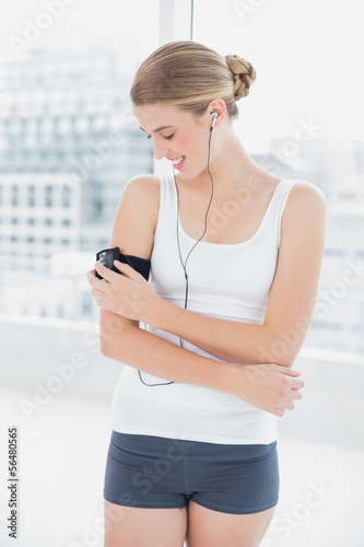 Happy sporty woman changing song on her mp3