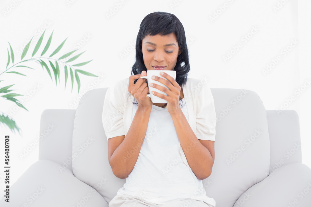 Natural black haired woman in white clothes enjoying coffee Natural black haired woman in white clothes enjoying coffee