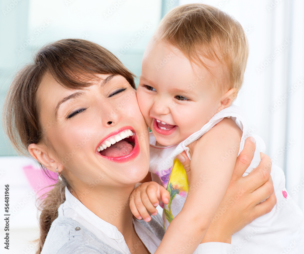 Happy Smiling Mother and Baby kissing and hugging at Home Happy Smiling Mother and Baby kissing and hugging at Home
