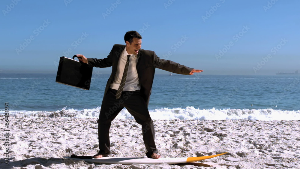 Smiling businessman balancing on a surfboard Smiling businessman balancing on a surfboard
