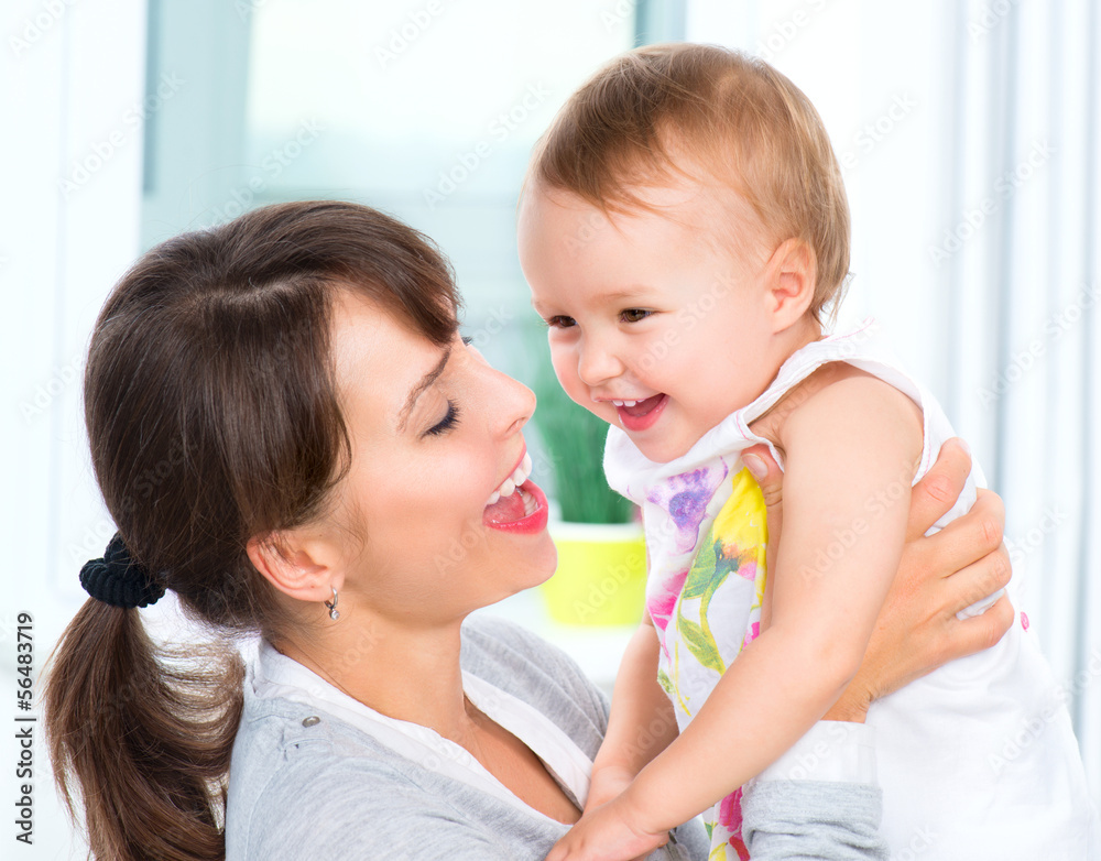 Happy Smiling Mother and Baby kissing and hugging at Home Happy Smiling Mother and Baby kissing and hugging at Home