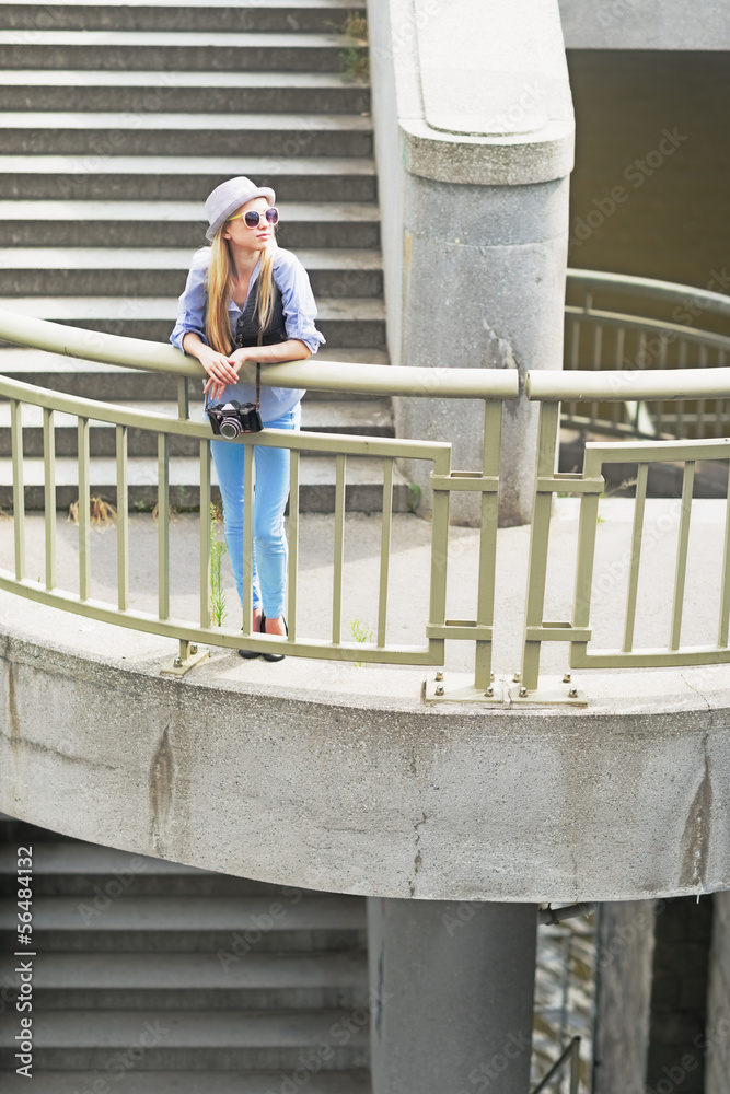 Hipster girl standing on stairs in city