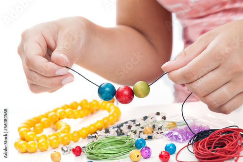 Fototapeta Girl's hands beading necklace