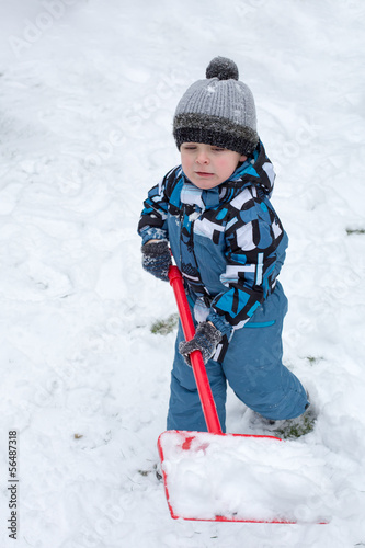 Adorable toddler boy happy about snow in winter