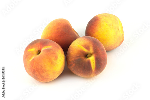 Four ripe fresh appetizing peaches isolated on white background