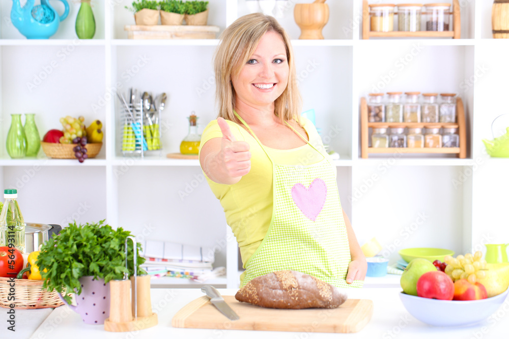 Happy smiling woman in kitchen preparing for healthy meal