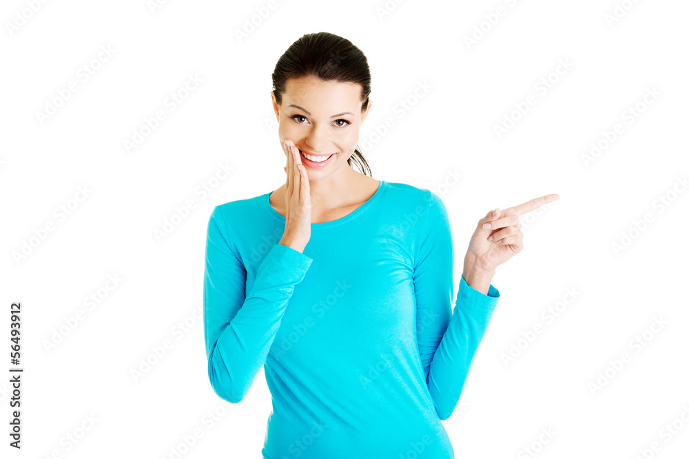 Excited young woman pointing on copy space Excited young woman pointing on copy space