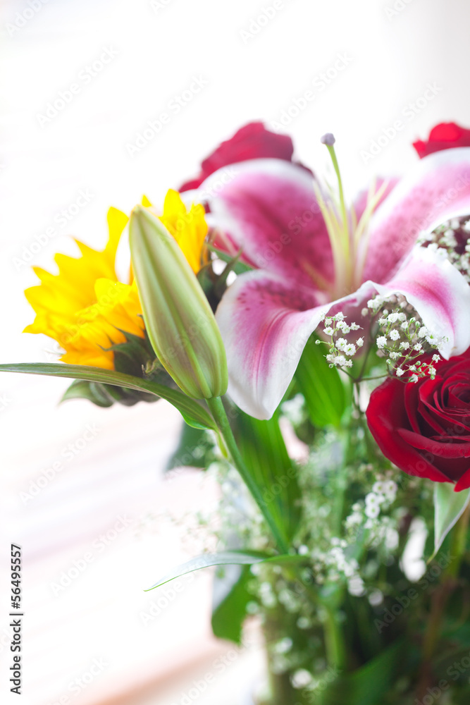 beautiful bouquet of sunflowers, lily and roses in a vase