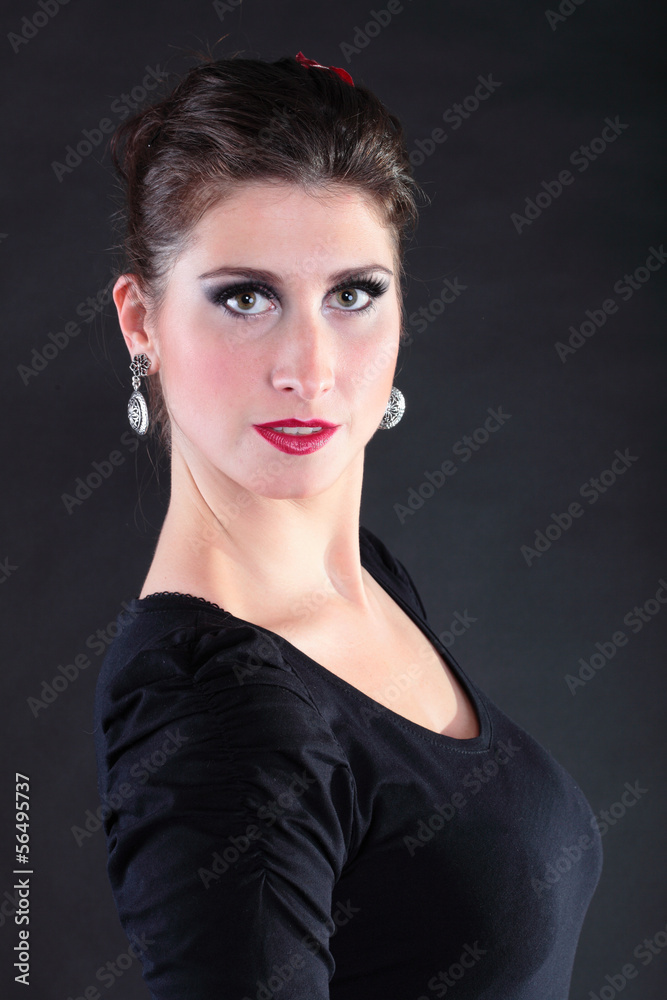 Attractive spanish young woman dancing flamenco over black backg Attractive spanish young woman dancing flamenco over black backg