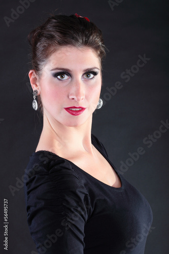 Attractive spanish young woman dancing flamenco over black backg