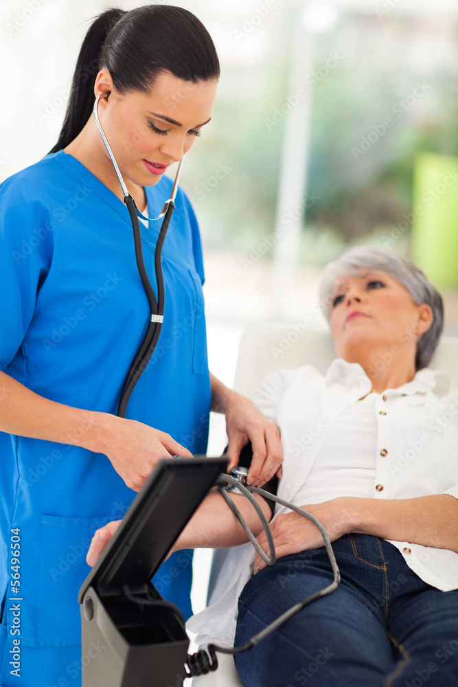 Obraz premium medical doctor checking senior patient's blood pressure