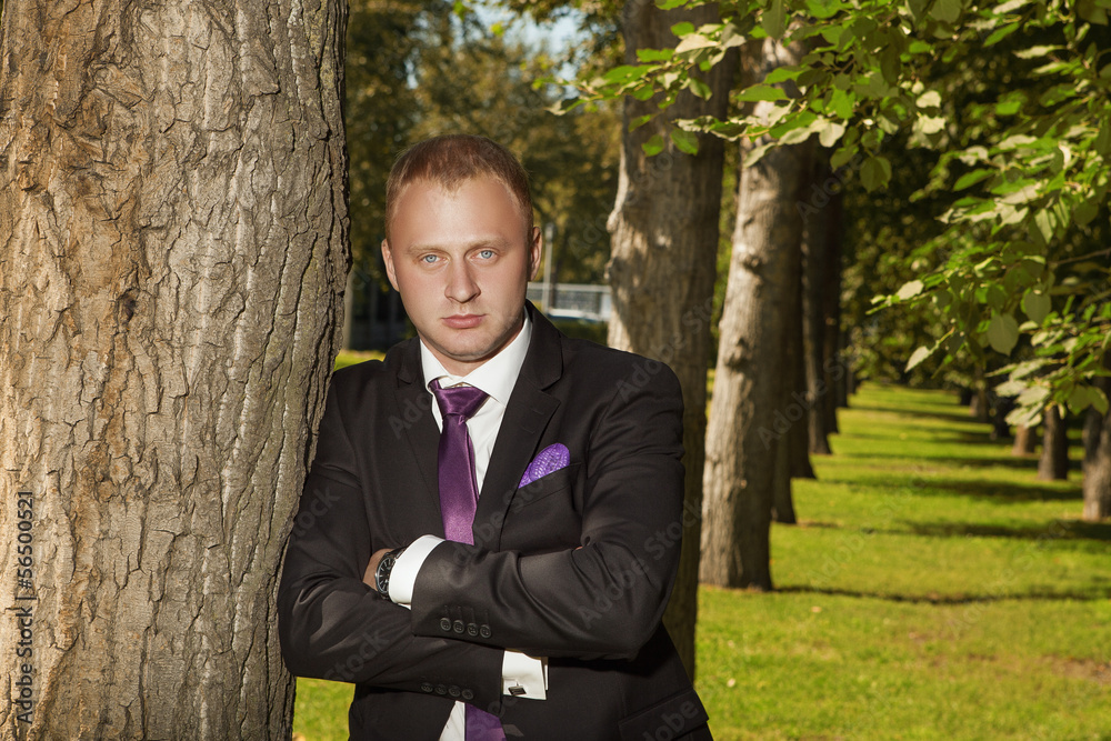 the groom in park near tree the groom in park near tree