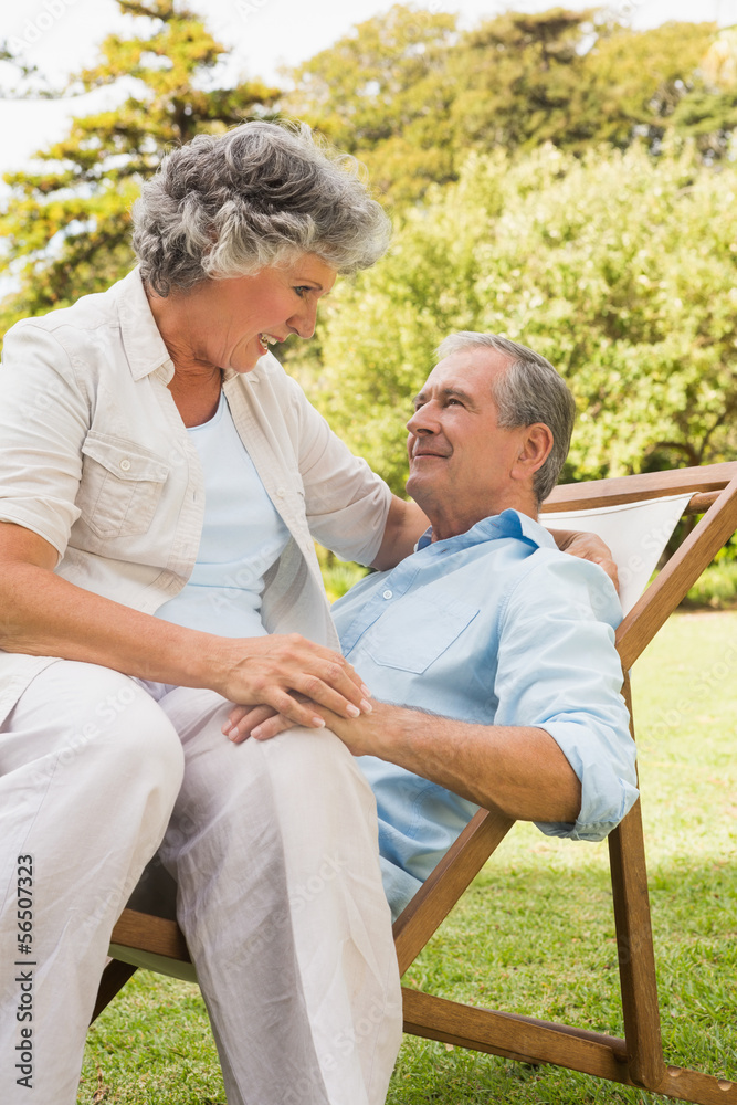 Happy mature couple sitting on sun lounger Happy mature couple sitting on sun lounger