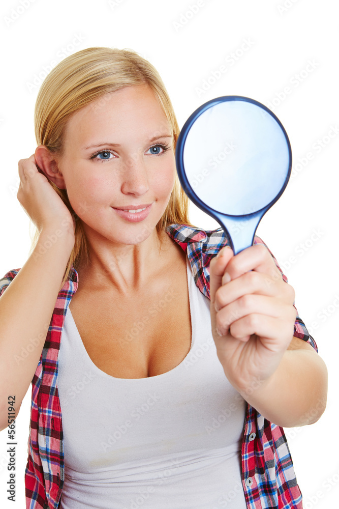Junge Frau schaut in einen Spiegel Junge Frau schaut in einen Spiegel