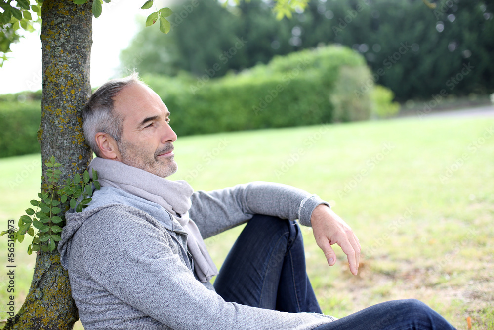 Senior man sitting in park and enjoying quietness Senior man sitting in park and enjoying quietness