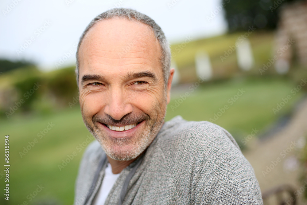 Fototapeta premium Cheerful casual senior man in countryside