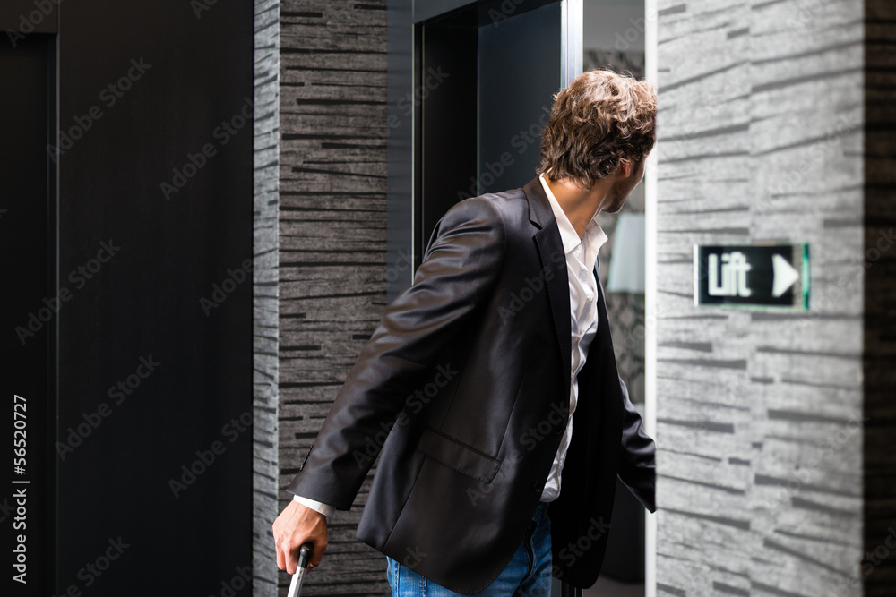 Young guest with luggage entering hotel room