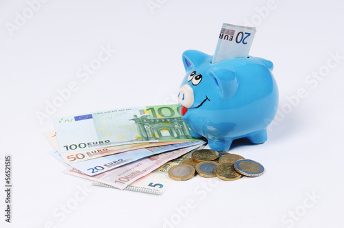 blaues Sparschwein mit Euro Scheinen und Euro Münzen photo