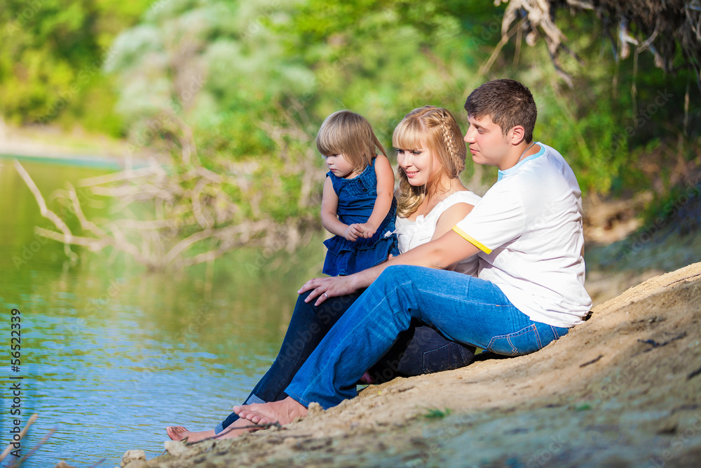 happy young family spending time outdoor on a lake happy young family spending time outdoor on a lake