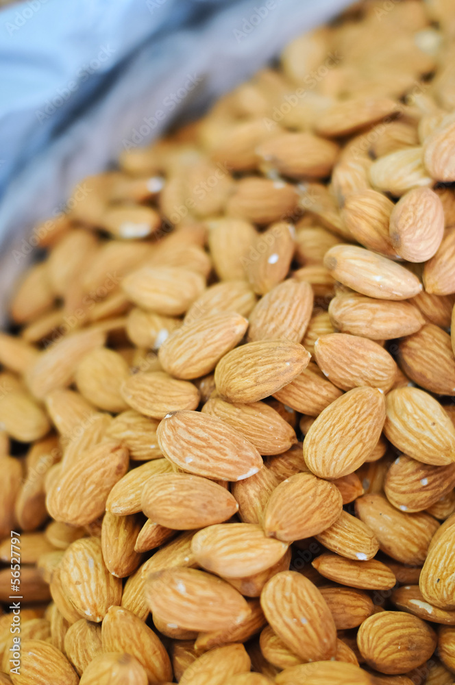 Obraz premium Heap of raw almonds nuts background