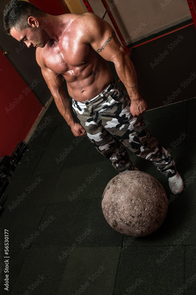Muscular Man Resting After Picking Up A Stone