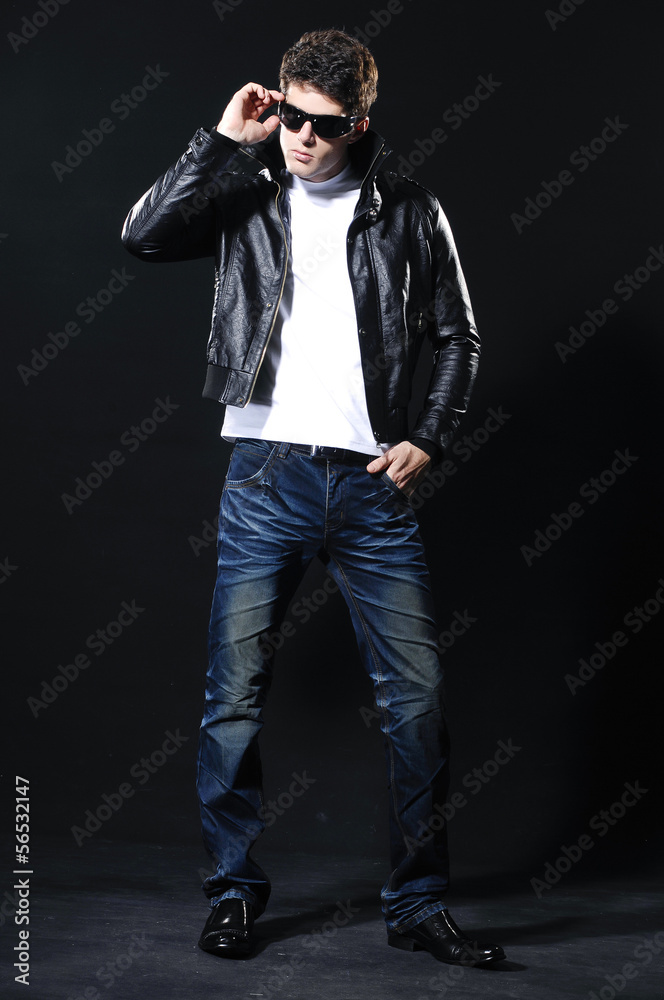 Plakat young casual man in sunglasses full body on a black background