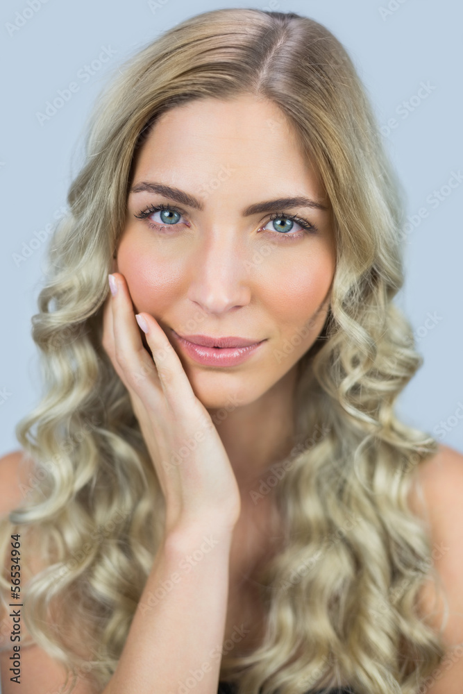Thoughtful gorgeous blond model posing touching her face Thoughtful gorgeous blond model posing touching her face