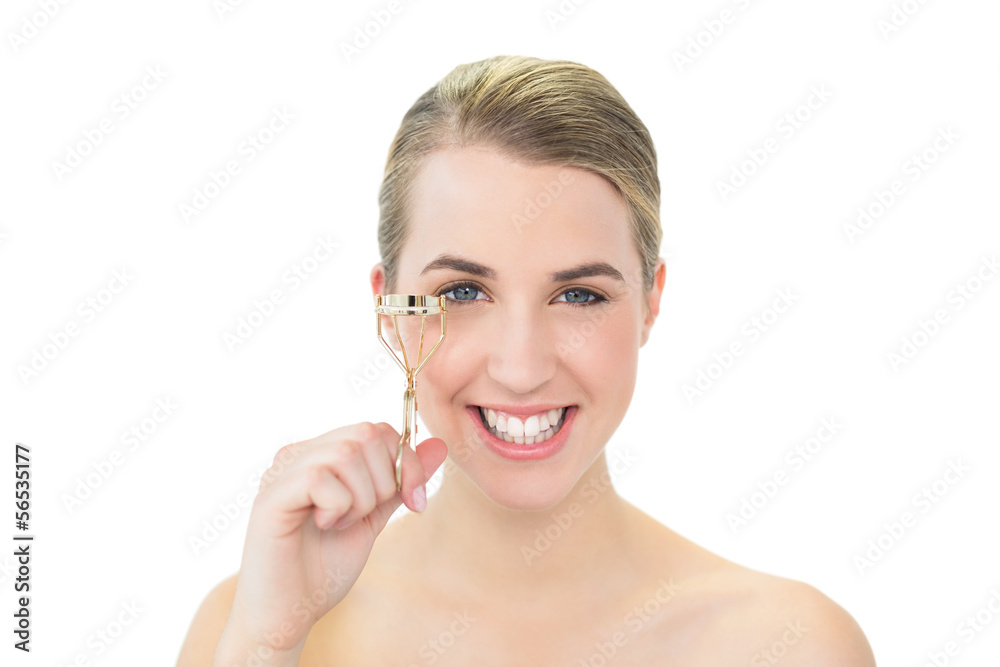Smiling attractive blonde holding eyelash curler Smiling attractive blonde holding eyelash curler