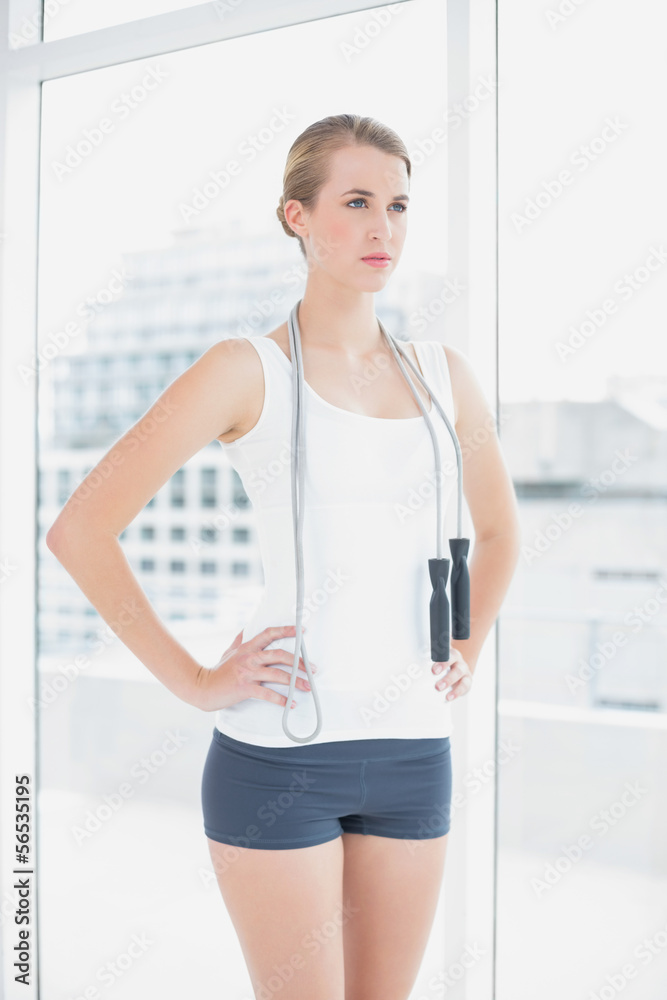 Serious sporty woman holding skipping rope