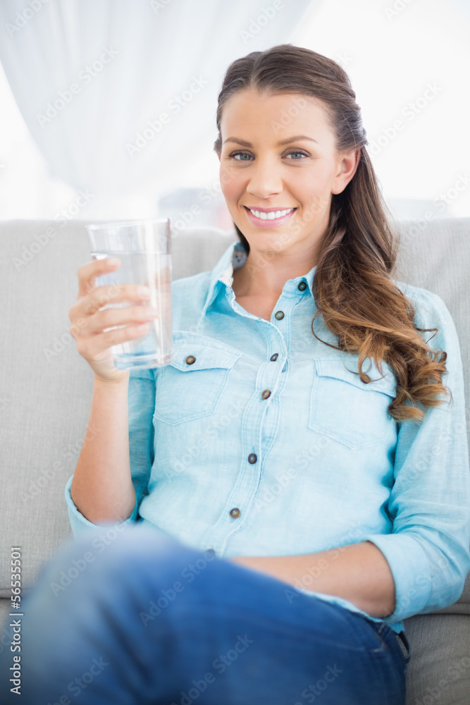 Gorgeous casual woman on couch holding glass of water Gorgeous casual woman on couch holding glass of water