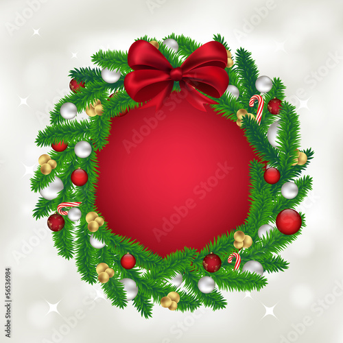 Christmas wreath of fir tree with balls, candy and a red bow