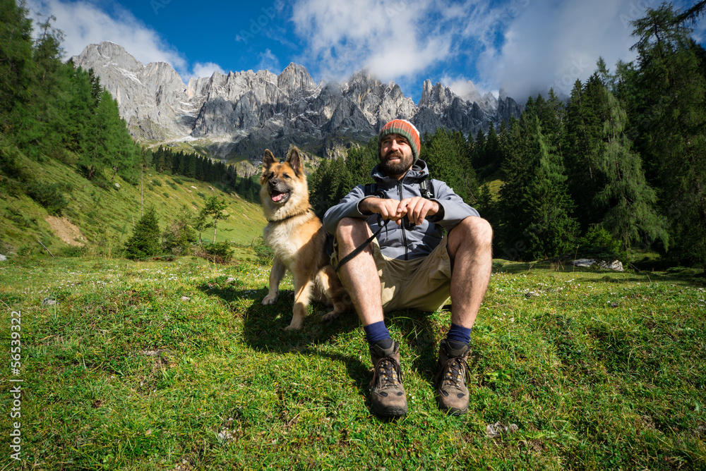 Obraz premium Lachender Mann mit seinem Hund macht Pause