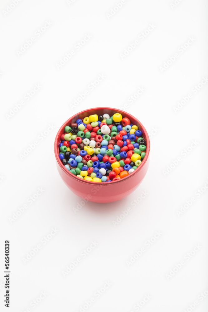 cup of colorful beads isolated on white background