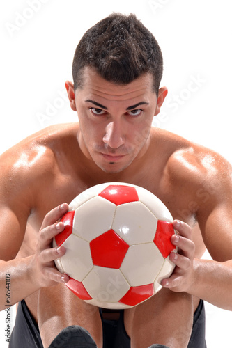 Jugador de fútbol sujetando un balón,entrenamiento.