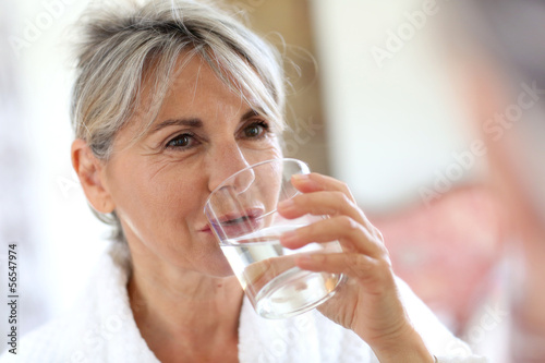 Fototapete Senior woman drinking water in the morning