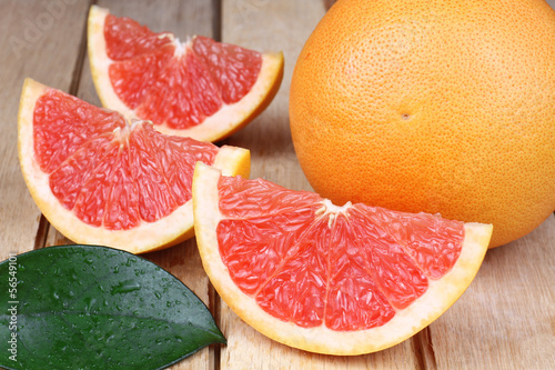 Sliced red grapefruit on a wooden background photo