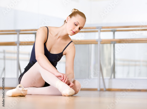 Ballet dancer laces the ribbons of the pointes