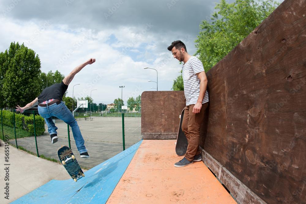 Skateboarder rolling down from halfpipe at skatepark. Skateboarder rolling down from halfpipe at skatepark.
