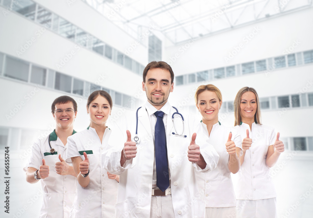 A tam of young and smart medical workers holding thumbs up A tam of young and smart medical workers holding thumbs up