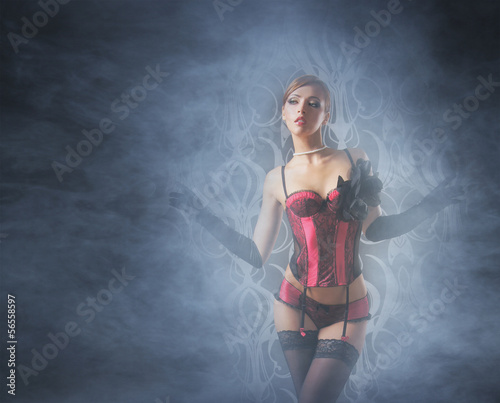 A young and sexy redhead cabaret dancer on a foggy backroung © Acronym