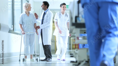 Multi Ethnic Staff Moving Patients Hospital Corridor