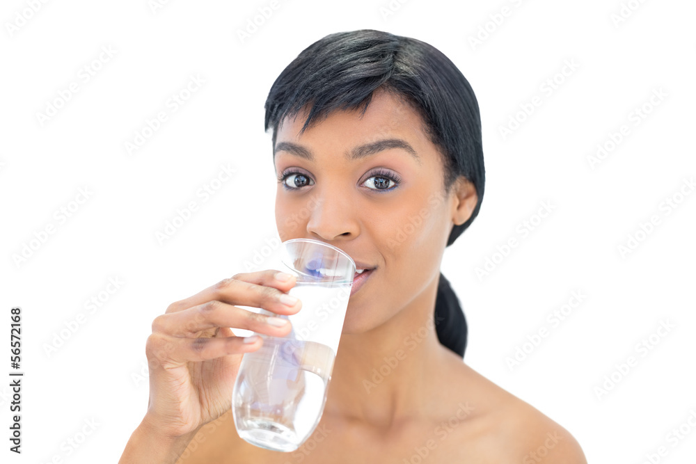 Amused black haired woman drinking a glass of water Amused black haired woman drinking a glass of water